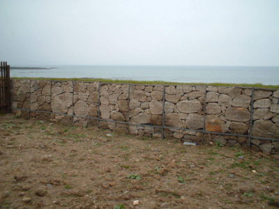 A Gabion retaining wall a grass face on top.