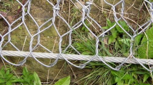 The steel cable holds the rock netting securely in place.